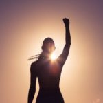 woman fist pump rising sun