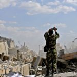 Syrian Soldier surveys wreckage