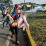 injured demonstrator carried away from protest in Caracas, Venezuela
