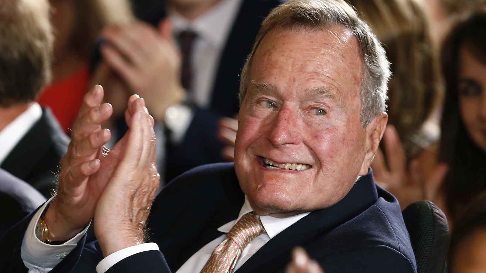 Former President George H. W. Bush applauds during an event at the White House
