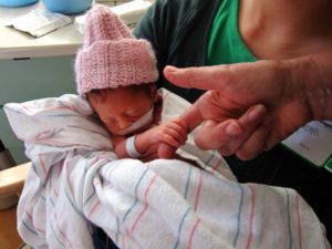 Premie bablie holds daddy's finger