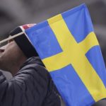 Man holding Swedish flag