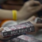 People hold out Bibles for President Donald Trump and first lady Melania Trump to sign