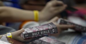 People hold out Bibles for President Donald Trump and first lady Melania Trump to sign
