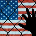 US flag behind chain-link fence