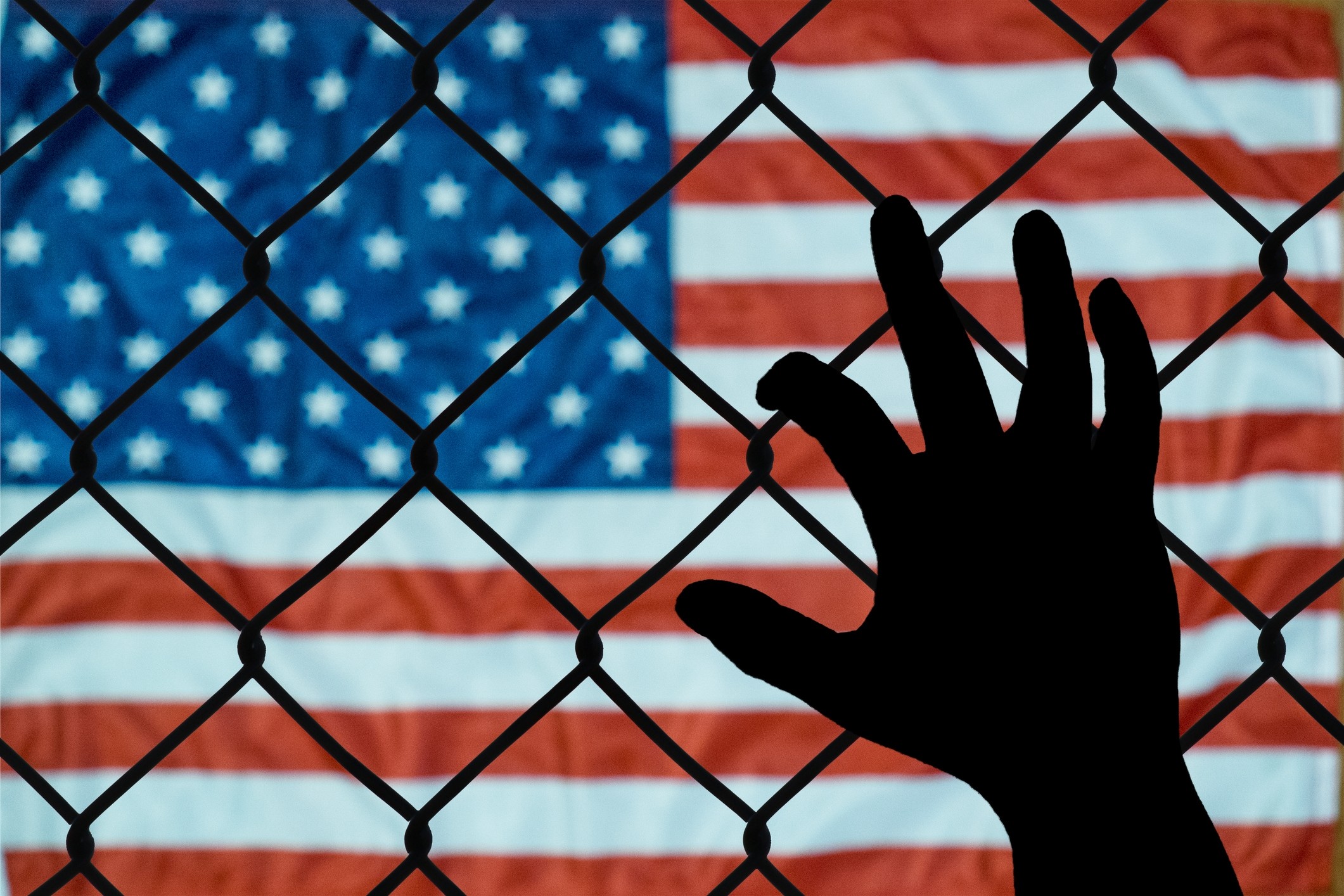 US flag behind chain-link fence