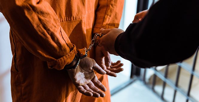 prisoner in jail being handcuffed