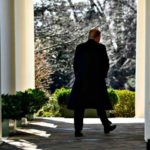 Coated President Trump walks on White House Porch