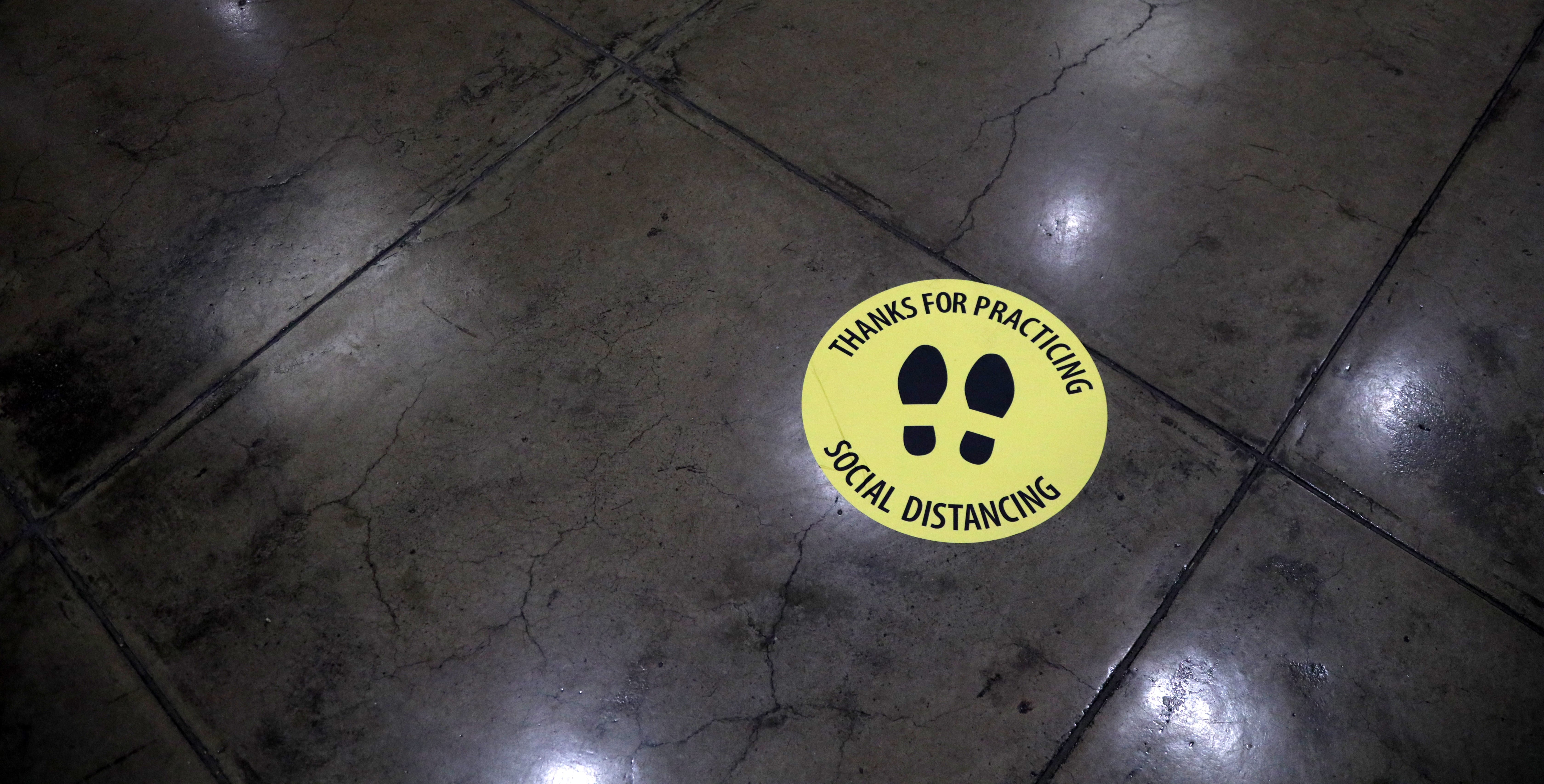 Social Distancing sticker on cement floor