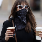 Woman in bandana mask carries 2 coffees