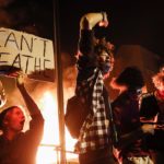 Rioters protest with fire and "I can't breathe" sign