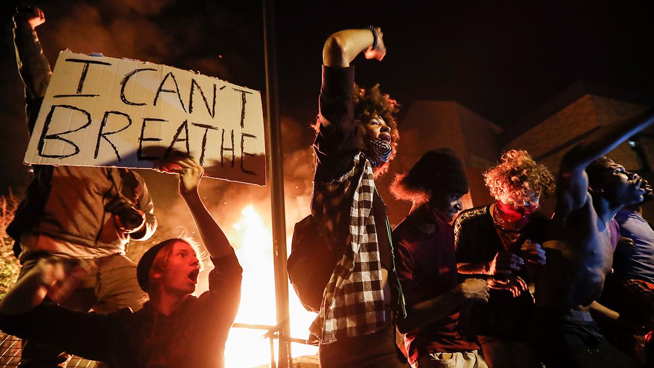 Rioters protest with fire and "I can't breathe" sign