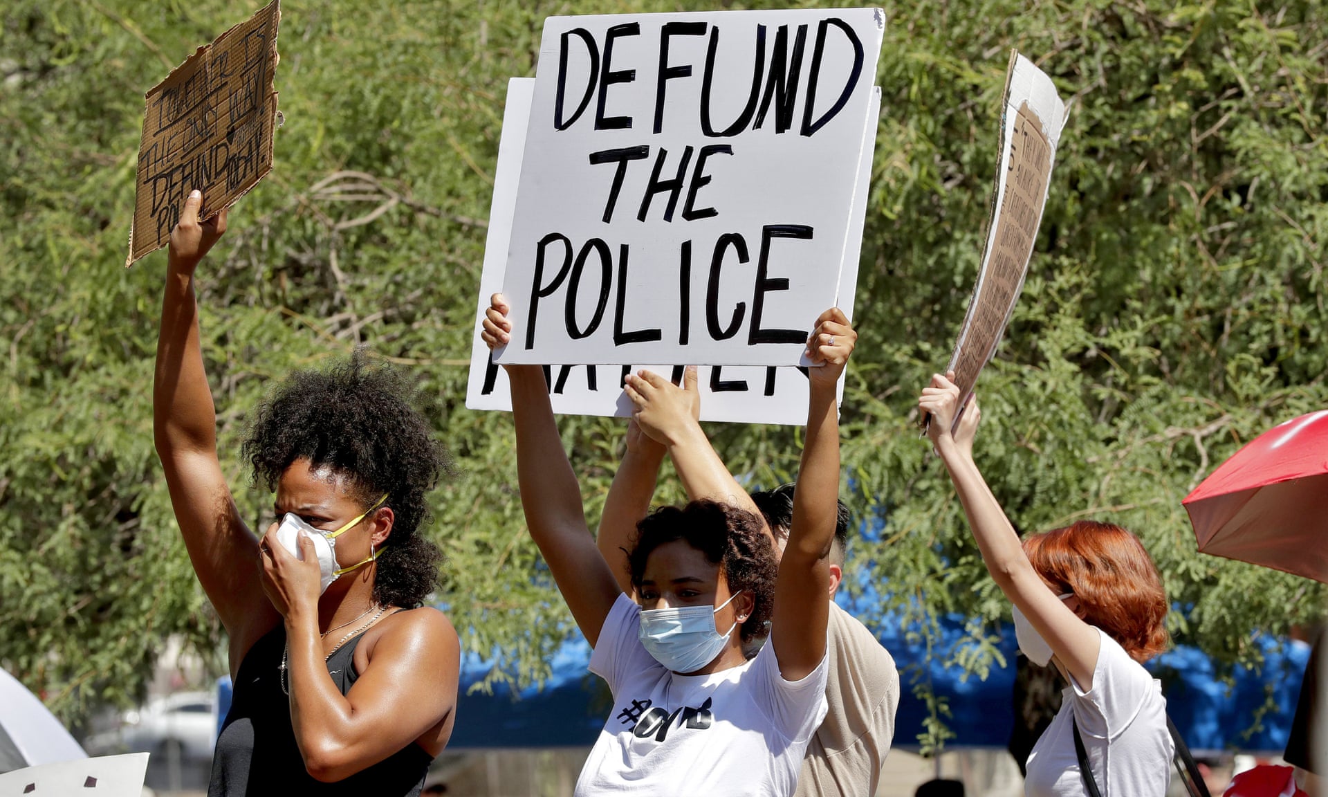 Protesters hold Defund the Police signs