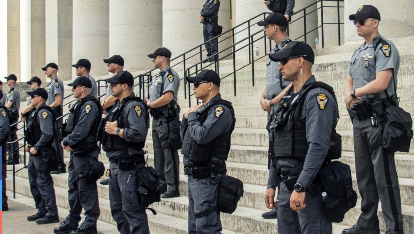 Police stand in rows on steps