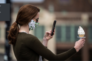 Masked woman takes selfie w ice cream cone