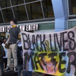 white protesters hold Black Lives Matter Sign