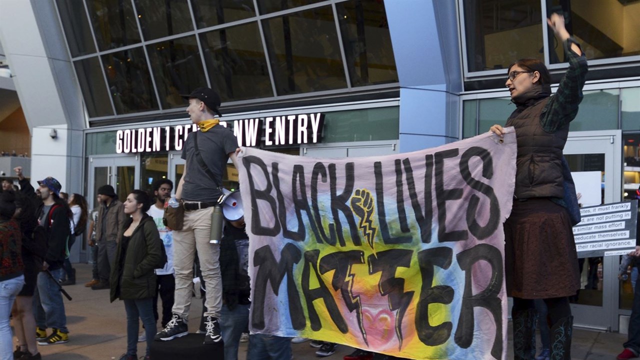 white protesters hold Black Lives Matter Sign