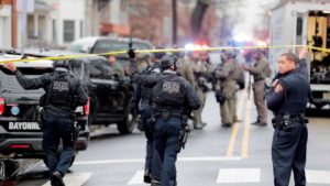 riot gear clad police cross under yellow crime-scene tape
