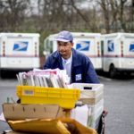 postal worker pushing mail cart