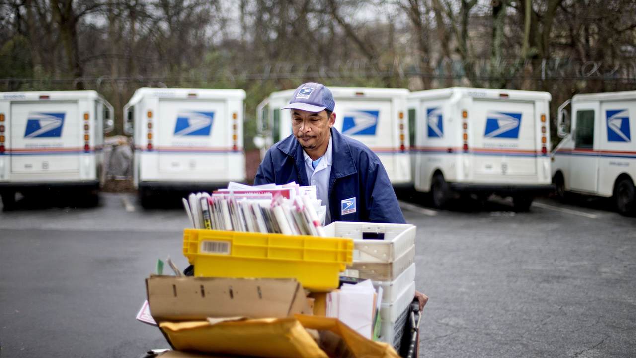 postal worker pushing mail cart