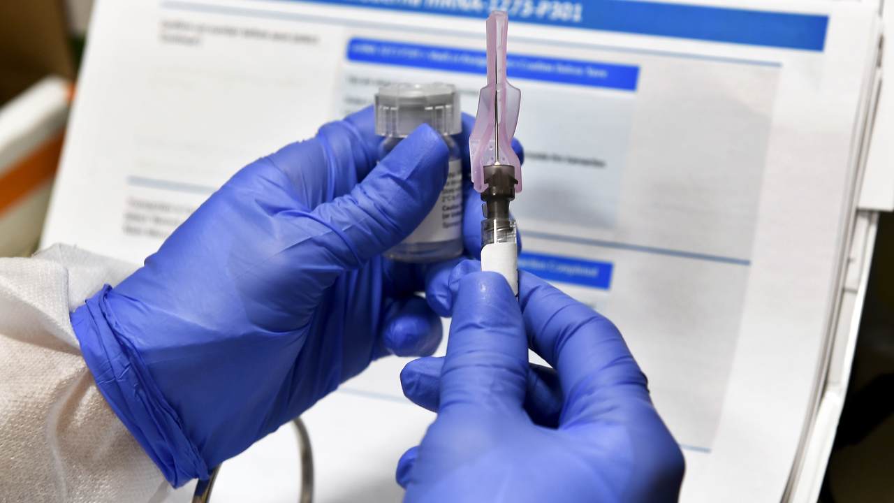 medical worker's hands vial and syringe