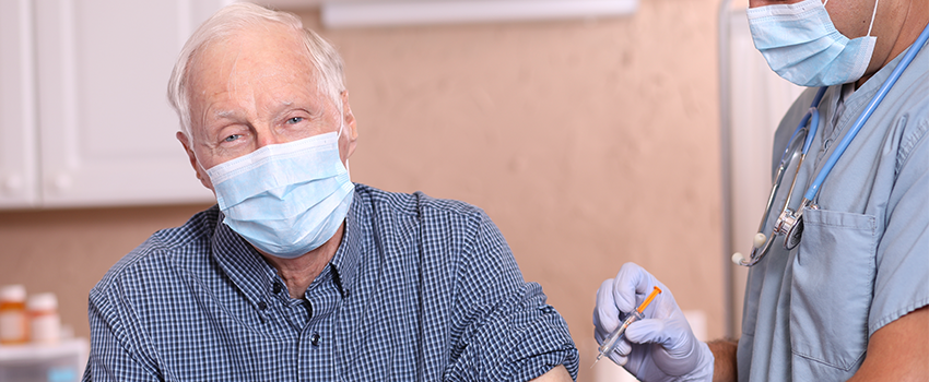 Masked Old person getting vaccine