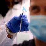 health-care-worker prepares covid-vaccine-