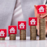 Businesswoman Placing Red Cubic Block With House Icon