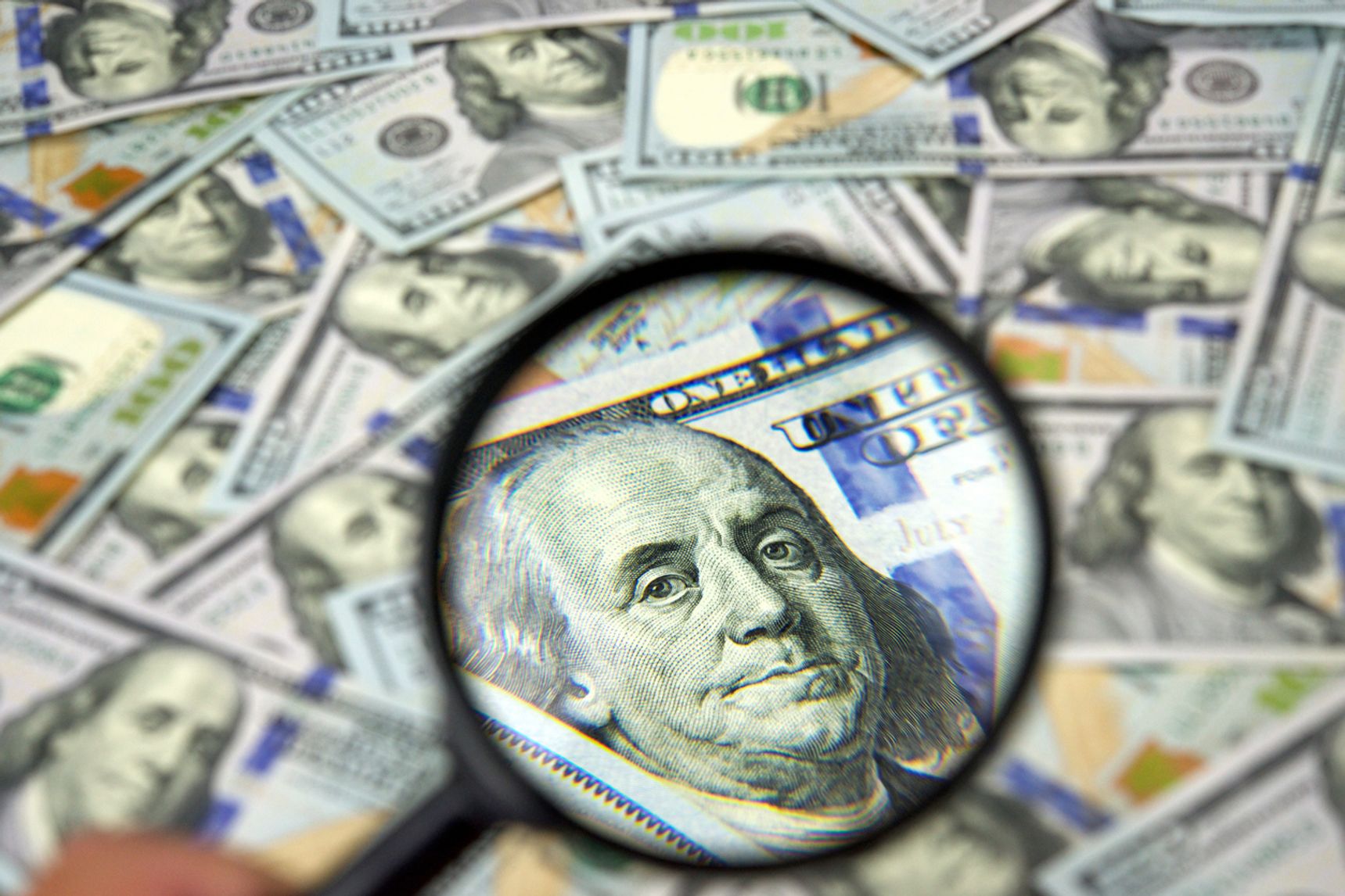 $100 bills magnifying glass on Ben Franklin