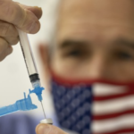 Vaccine syringe US flag masked person