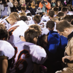 Coach Joe Kennedy Prays w/ team