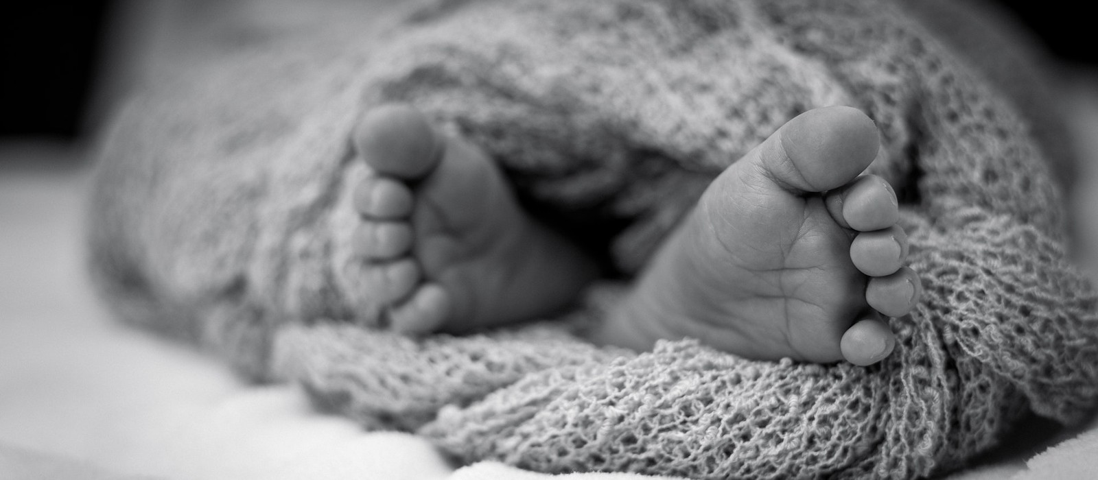 baby feet in knitted blanket - B&W
