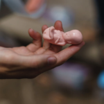 hand holding tiny newborn doll