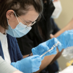 pharmacist fills a syringe with one dose of the JYNNEOS smallpox and monkeypox vaccine