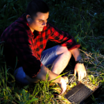 sitting in the dark, in grass w laptop