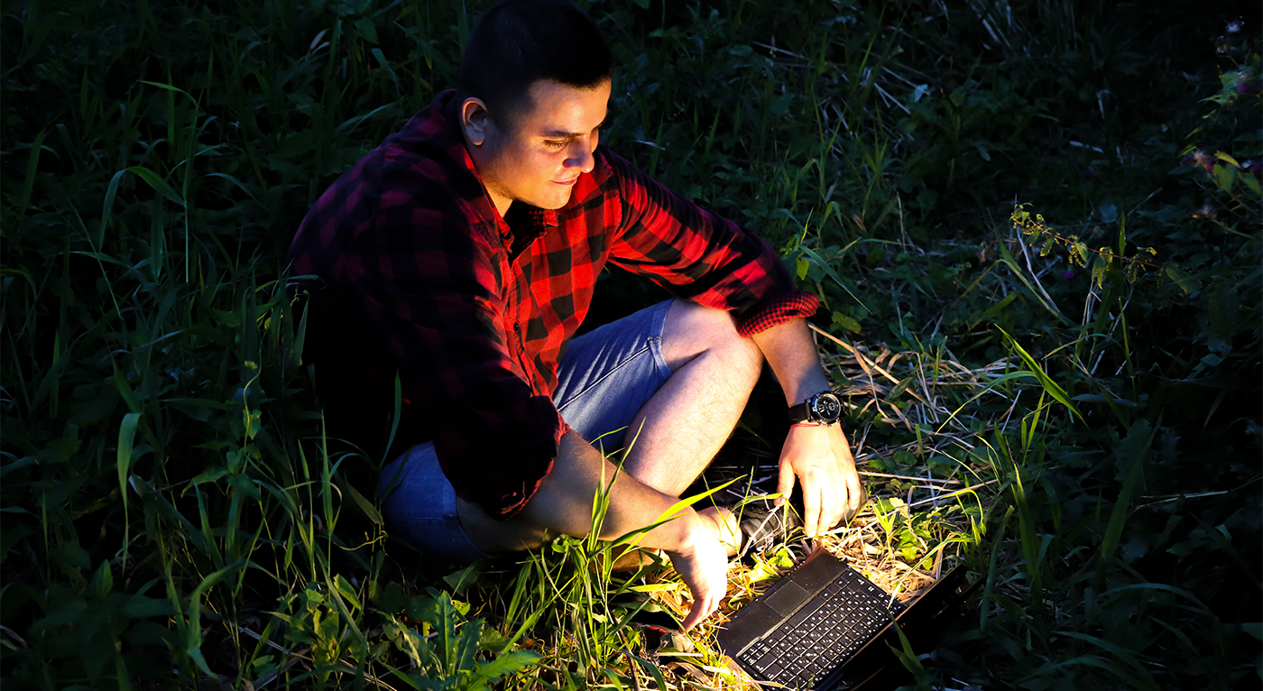 sitting in the dark, in grass w laptop