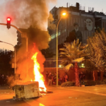 A police motorcycle burns during a protest over the death of Mahsa Amini, a woman who died after being arrested by the Islamic republic's "morality police," in Tehran, Iran