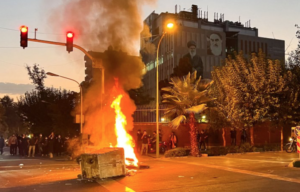 A police motorcycle burns during a protest over the death of Mahsa Amini, a woman who died after being arrested by the Islamic republic's "morality police," in Tehran, Iran