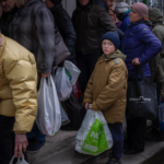 Hungry people wait in line for food