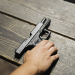 pistol & hand on wooden table