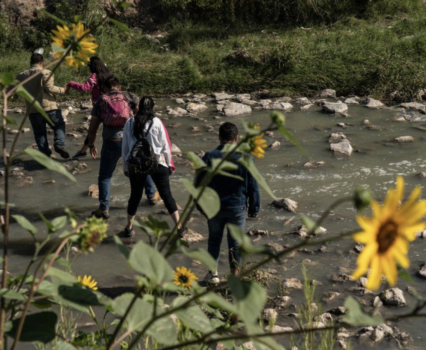 illegal immigrants step on stones to cross Rio Grande