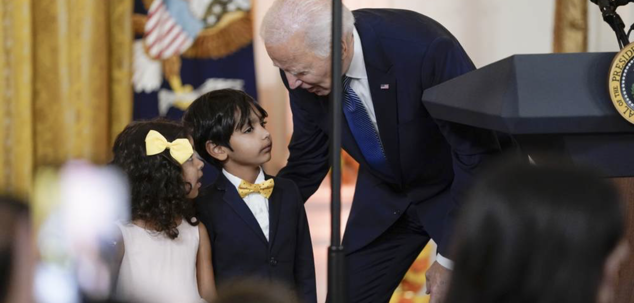 Biden bends over to talk to small boy & girl