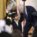 Biden bends over to talk to small children