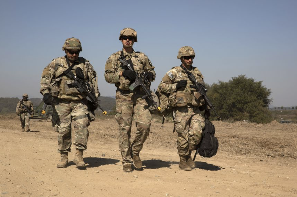 US troops walking or patrolling thru arid territory
