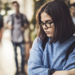 depressed teen girl in school hallway