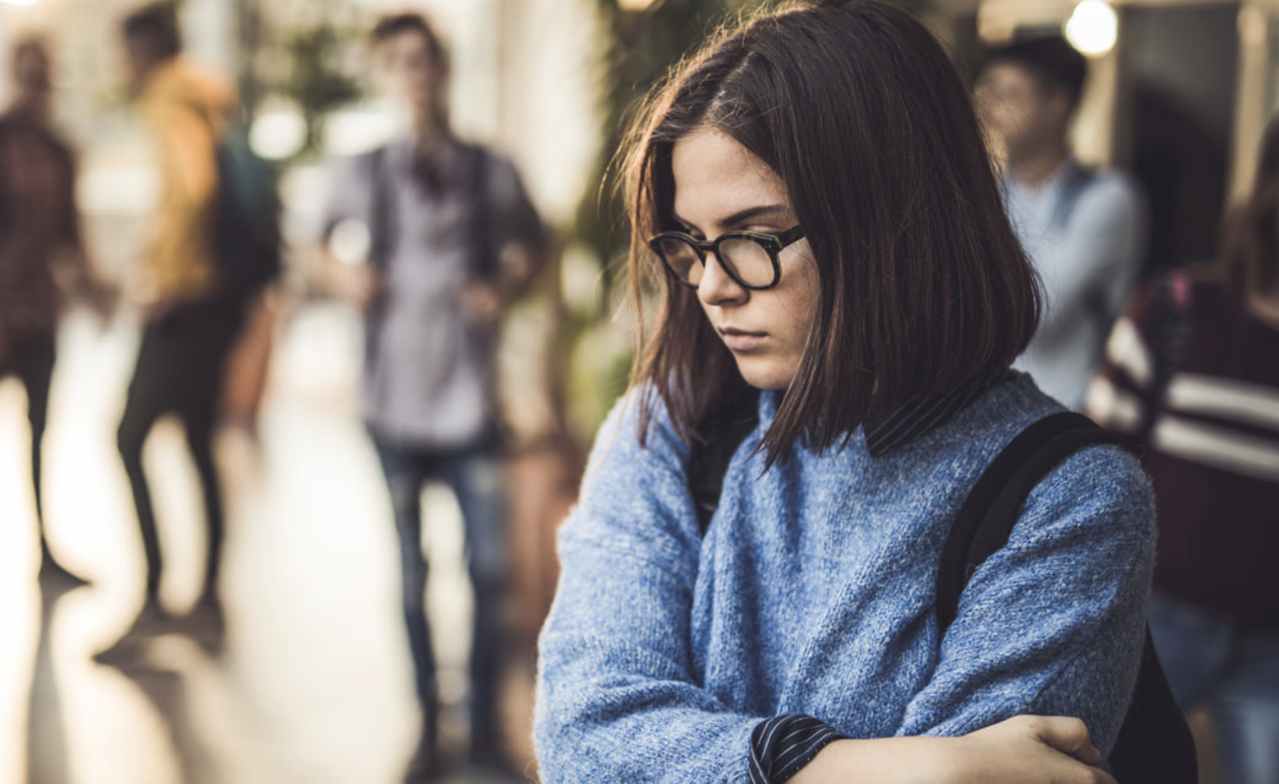 depressed teen girl in school hallway