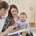 Dr. examines baby with Mom