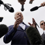 biden surrounded by microphones - reporters