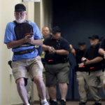 Stephen Hatherley, left, leads fellow trainees down a hallway - Haslet, TX