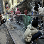 Recently-arrived migrants waiti outside Roosevelt Hotel, midtown Manhattan